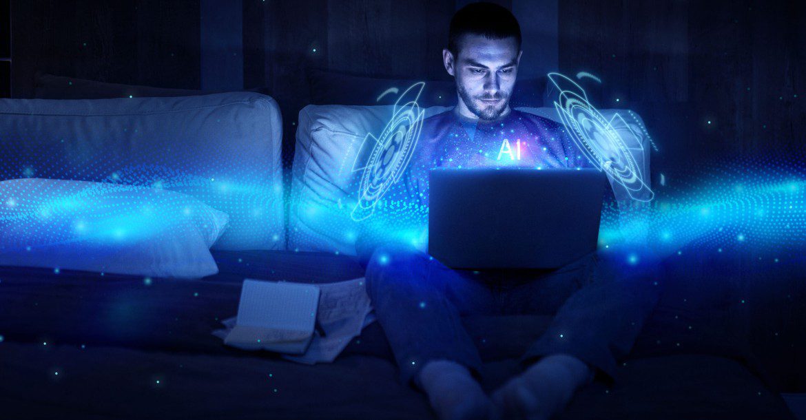 The Future of TV: Exploring the World of IPTV 7 A man sits on a couch, intently using a laptop with a glowing, blue holographic interface labeled "AI" appearing in front of him, evoking a futuristic concept. Papers are scattered beside him on the dimly lit couch. Perhaps he's tuning into kemoiptv for some high-tech inspiration.