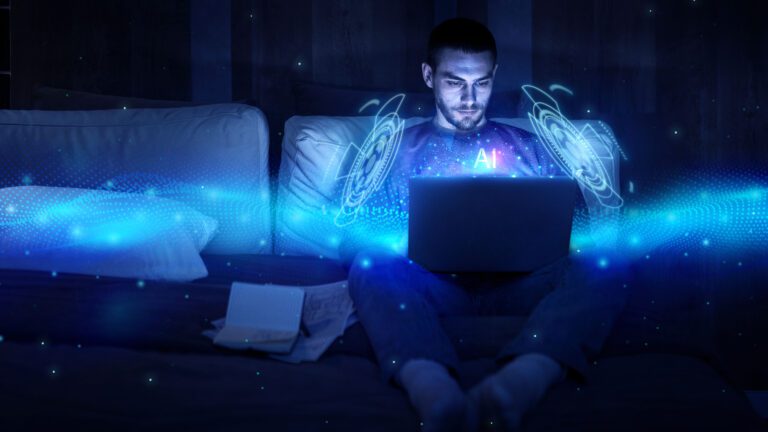 A man sits on a couch, intently using a laptop with a glowing, blue holographic interface labeled "AI" appearing in front of him, evoking a futuristic concept. Papers are scattered beside him on the dimly lit couch. Perhaps he's tuning into kemoiptv for some high-tech inspiration.