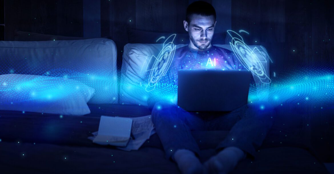 A man sits on a couch, intently using a laptop with a glowing, blue holographic interface labeled "AI" appearing in front of him, evoking a futuristic concept. Papers are scattered beside him on the dimly lit couch. Perhaps he's tuning into kemoiptv for some high-tech inspiration.